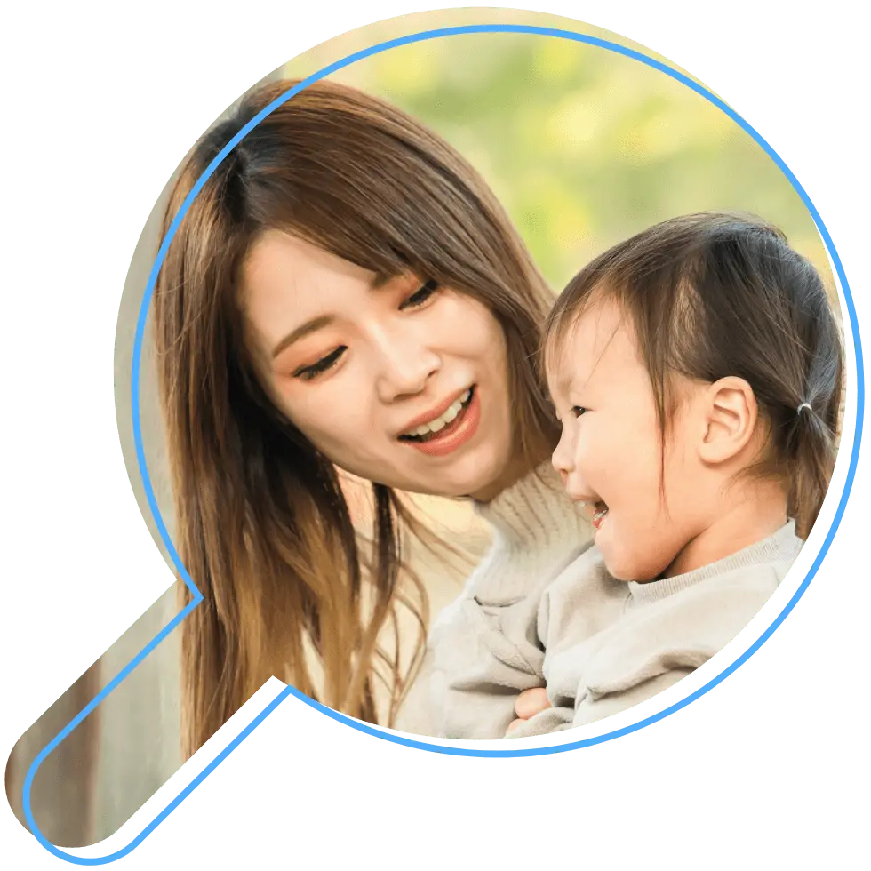 母親に2歳前後の娘が抱きしめられ、お互いに笑顔を浮かべている